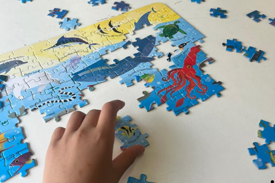 A child completing a puzzle. STEM learning.